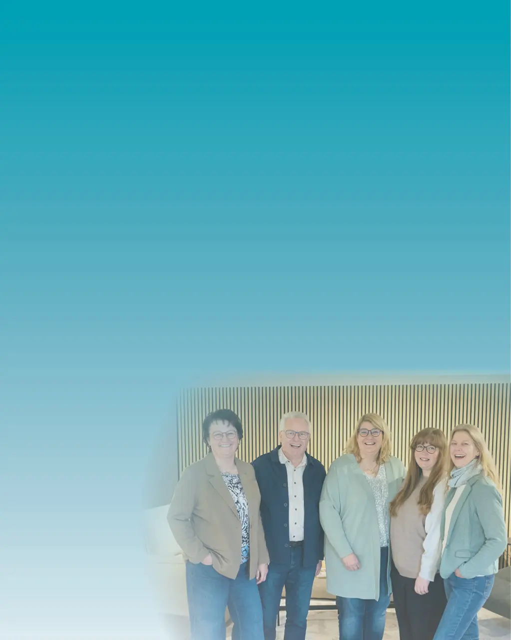 Team für Raumgestaltung und Einrichtungsberatung im Möbelhaus. Fünf Mitarbeiter stehen gemeinsam vor moderner Holzlamellenwand und präsentieren Kompetenz in Wohnberatung, Möbelplanung und individueller Raumgestaltung.